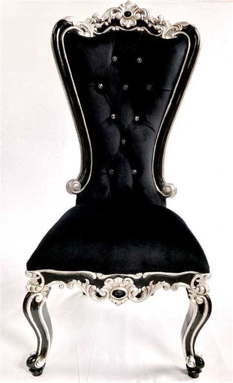 An Ornate Black Chair With Silver Trimmings And Buttons On The Back