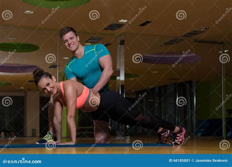 Personal Trainer Helping Client In Gym With Push Ups Stock Image