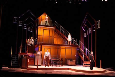 Three People Standing On Stage In Front Of A Building With Stairs And