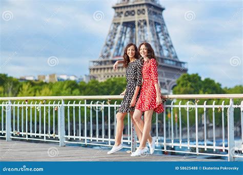 Twin Sisters In Front Of The Eiffel Tower In Paris France Stock Photo
