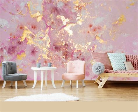 A Living Room With Pink And Gold Paint On The Wall Two Chairs And A Table
