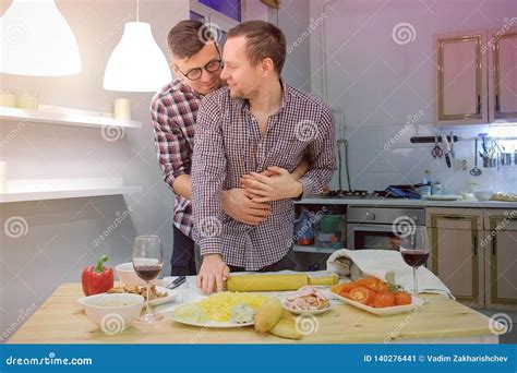 Accoppi Degli Uomini Che Il Gay Si Flirta Che Cucina Insieme Una Pizza E Che Beve Un Vino