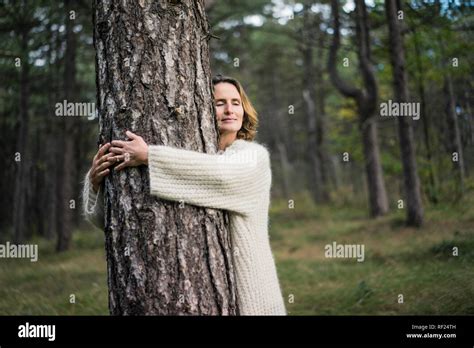 Woman Hugging Tree In Forest Stock Photo Alamy