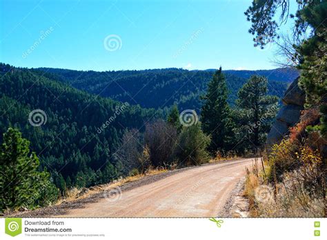 Unpaved Dirt Mountain Road On The Edge Of A Cliff In A Pine Tree Stock