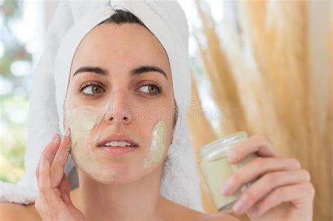 Portrait Of Beautiful Woman Putting Cosmetic Mask On Her Face To Purify