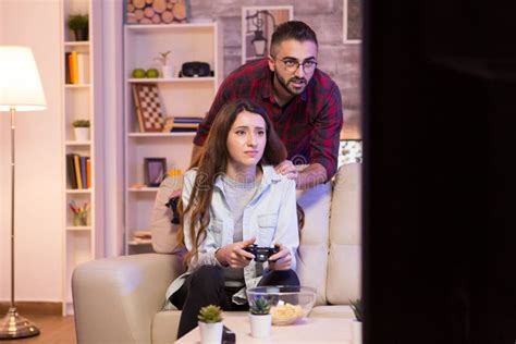 Boyfriend Helping His Girlfriend To Win At Video Games Stock Image