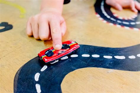 Child Plays With Two Miniature Cars In A Toy Circuit Stock Image