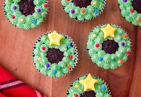 Cupcakes Decorated With Green And Purple Frosting On A Wooden Table
