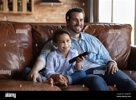Padre Feliz Con Hijo Pequeño Viendo La Televisión Sentado En El Sofá