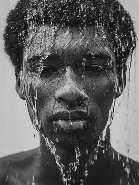 A Man With Water All Over His Face And Neck Covered In Black Mud From