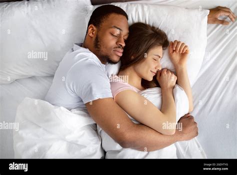 Top View Of Loving Interracial Couple Sleeping In Bed Hugging Each Other Diverse Love And