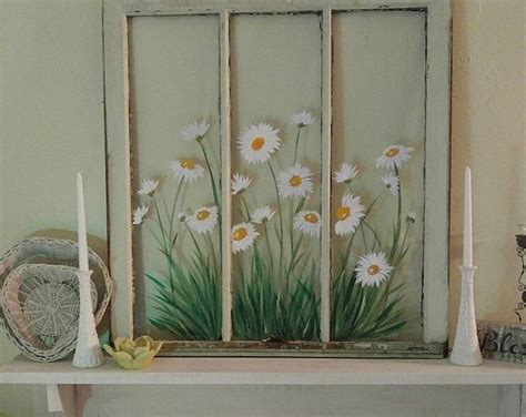 An Old Window With Daisies Painted On The Side And Candles In Front Of It