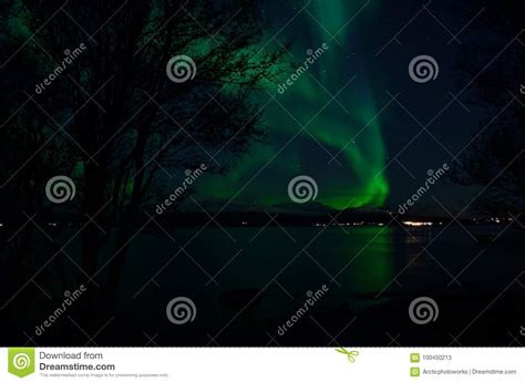 Vibrant Aurora Borealis Over Fjord And Mountain Refleting In Sea Stock