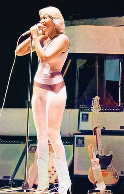 a woman in tights singing into a microphone