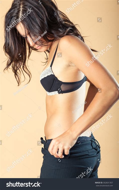 Provocative Brunette Takes Off Her Suit Stock Photo