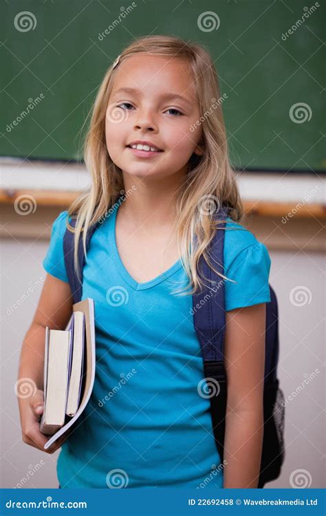 Portrait Of A Blonde Schoolgirl Holding Her Books Royalty Free Stock