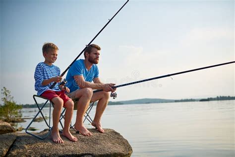 Father And Son Fishing Together In Still Waters Stock Image Image Of