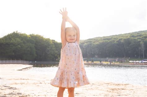 Cute Kid Girl In Dress With Funny Tails Hands Up Having Fun On Nature On Sunny Summer Day