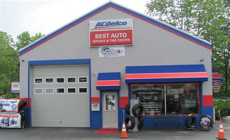 An Auto Repair Shop With Two Cars Parked In Front Of The Garage And