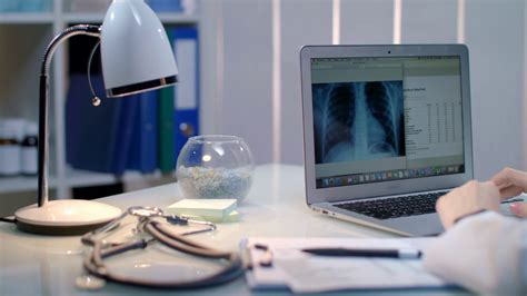 Doctor Working With Xray On Laptop At Workplace Late