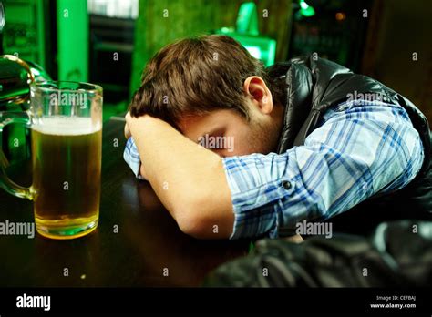 Young Man Sleeping In Pub With Glass Of Beer Near By Stock Photo Alamy