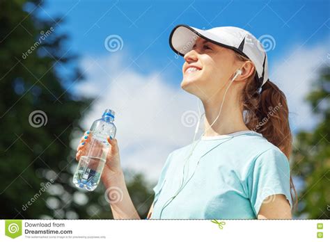 Portrait Of Happy Fitness Woman Drinking Water After Workout Stock