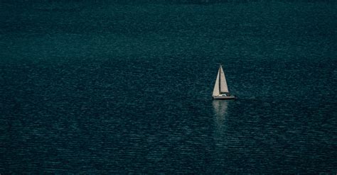Lonesome Sailboat Floating On Rippling Sea · Free Stock Photo