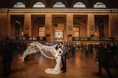 A Bride And Groom Standing In The Middle Of A Train Station