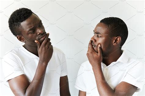 Portrait Of Two Cautious And Thoughtful Black Guys Wearing White T