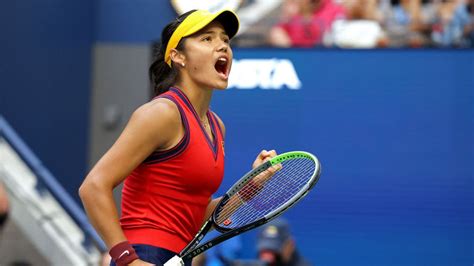 A Woman Holding A Tennis Racquet In Her Right Hand And Yelling At Something