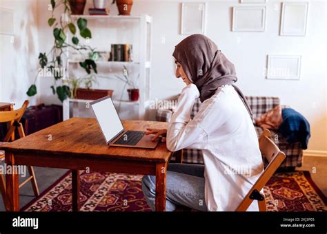 Eine Hübsche Junge Frau Aus Dem Nahen Osten Die Zu Hause Hijab Mit Einem Laptop Trägt Ein