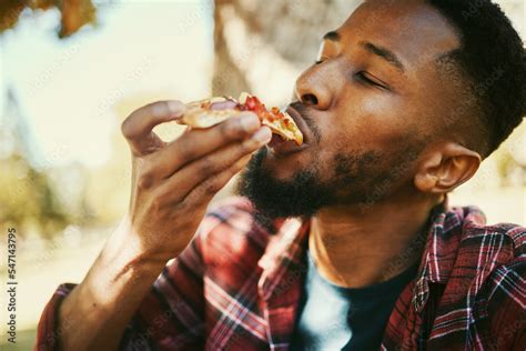 Fast Food Hungry And Black Man Eating Pizza For Delicious And Yummy Lunch Break In Park Gen Z
