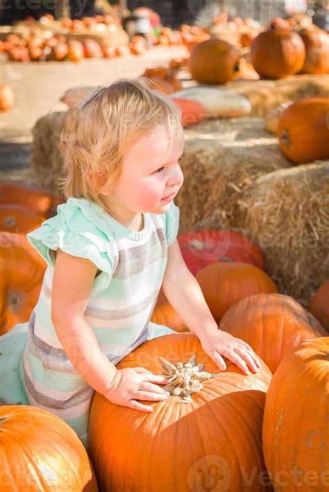 Adorable Baby Girl Having Fun In A Rustic Ranch Setting At The Pumpkin