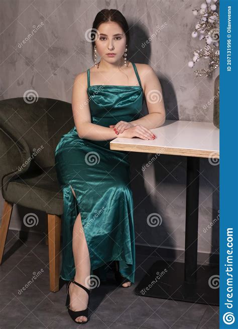 Attractive Brunette Woman In Elegant Green Aquamarine Dress In A Loft Cafe Beautiful Sensual