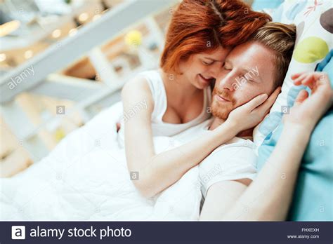 Romantic Couple In Love Lying On Bed And Being Passionate