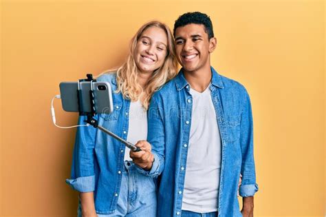Young Interracial Couple Taking A Selfie Photo With Smartphone Smiling With A Happy And Cool