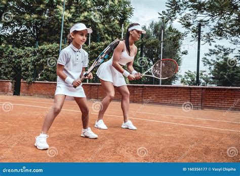 Tennis Training Cheerful Mother In Sports Clothing Teaching His Daughter To Play Tennis While