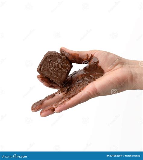 Female Hand Holding A Melted Piece Of Dark Chocolate Stock Image