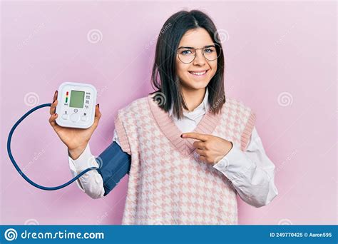 Young Brunette Woman Using Blood Pressure Monitor Smiling Happy