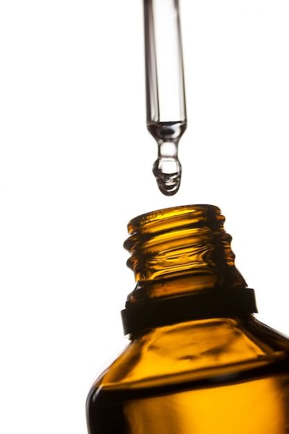 Free Photo Drop Of Oil Dripping From Pipette Into Bottle Of Essential Oil