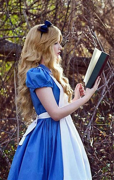 a woman in a blue and white dress holding a book