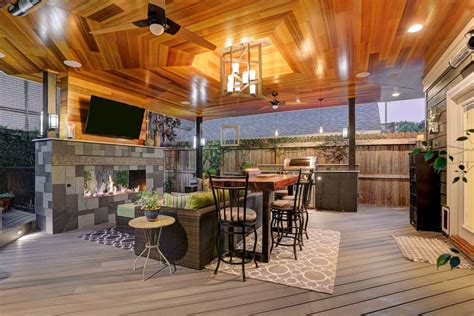 A covered outdoor living room features furniture groupings defined by area rugs. 50 Stylish Covered Patio Ideas