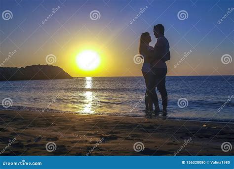 Silhouette Of Romantic Lovers Meeting Sunrise Sunset On The Sea Coast