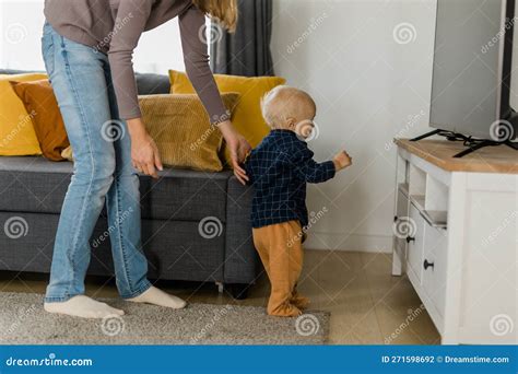 Baby Taking First Steps With Motherand X27s Help At Home Stock Photo