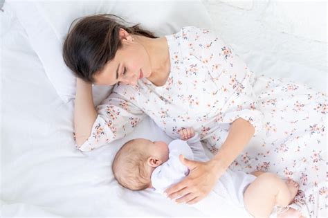 Premium Photo Mom And Newborn Baby Sleep Together Mom Puts Baby To