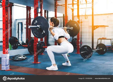 Fit Beautiful Girl Doing Squats With Barbell In Gym Stock Photo By