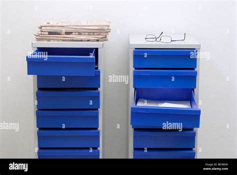 Glasses Newspapers And File Cabinet With Open Drawer Stock Photo Alamy