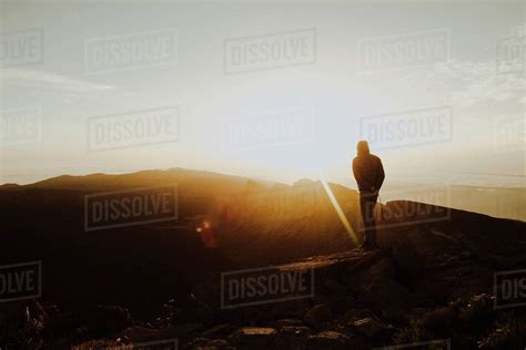 A Man Stands On Mountain Top Watching Sunrise Stock Photo Dissolve