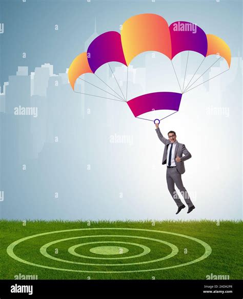 Young Businessman Falling On Parachute In Business Concept Stock Photo