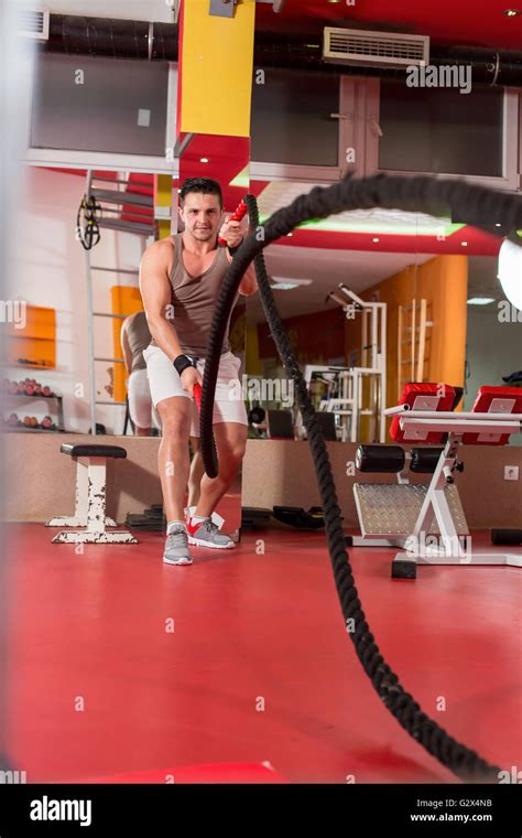 Young Man Working Out With Battle Ropes At A Gym Stock Photo Alamy